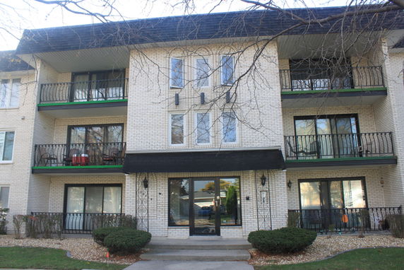 Front view of a multi-story apartment building with balconies.