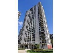 Front view of a tall residential building with multiple balconies.