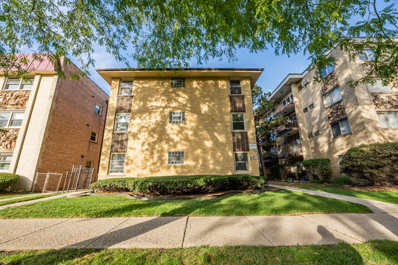 Front view of a mid-rise apartment building with brick exterior.