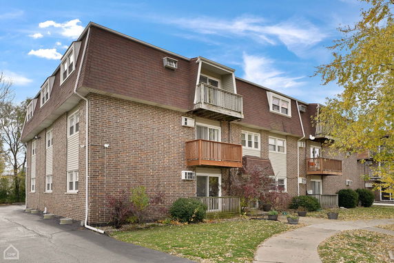 Front view of a multi-story building with balconies and a brick exterior.