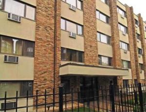 Front view of a multi-story apartment building with brick and beige exterior.