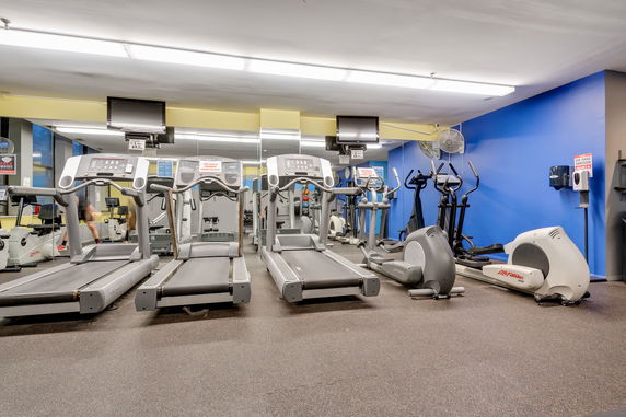Interior view of a gym with treadmills and exercise equipment.
