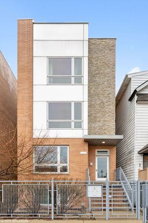 Front view of a modern multi-story house with large windows.