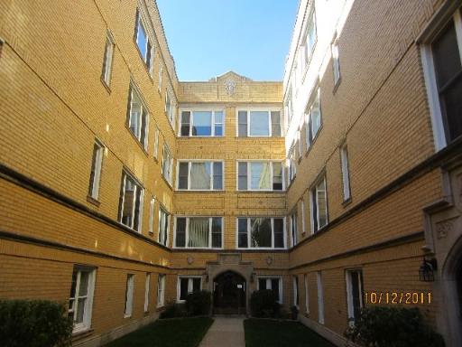 Front view of a multi-story brick building with multiple windows.