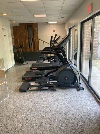 Indoor gym area with exercise equipment like treadmills and elliptical machines.
