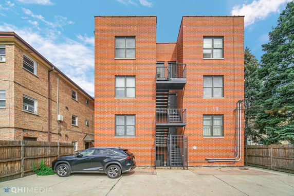 Front view of a brick apartment building with an external staircase.