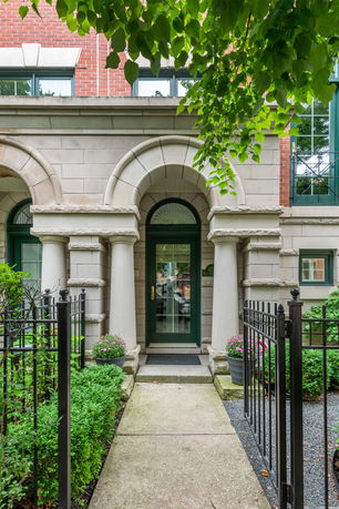 Front view of a building entrance with columns and arched doorway.