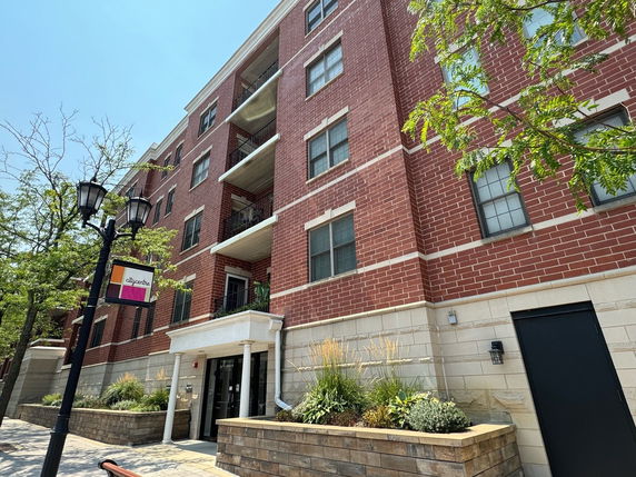 Front view of a multi-story apartment building with a brick exterior.