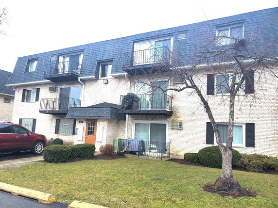 Front view of a three-story apartment building with balconies.