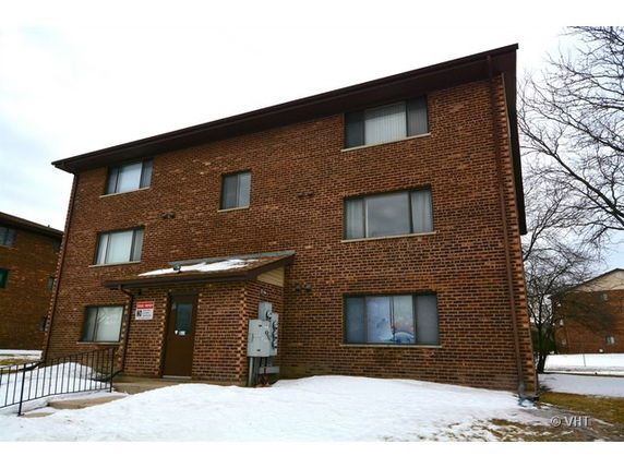 Front view of a three-story brick building with several windows and a main entrance.