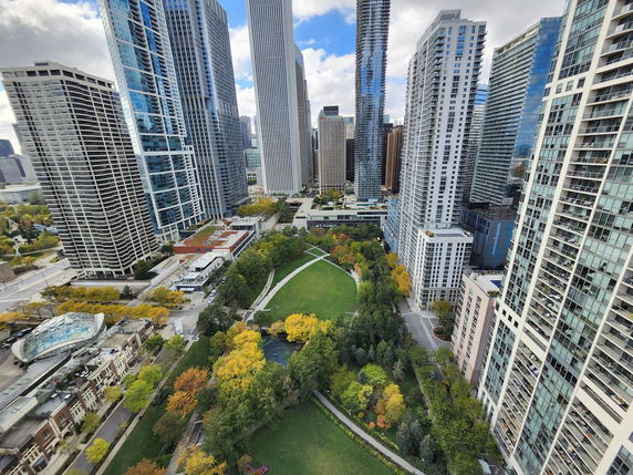 Panoramic view of a cityscape featuring tall skyscrapers and a large park area.