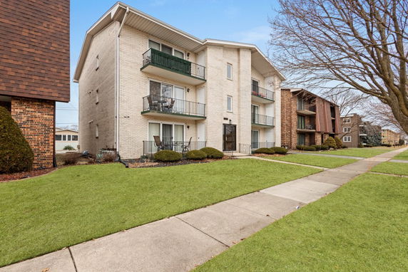 Front view of a multi-story apartment building with balconies.