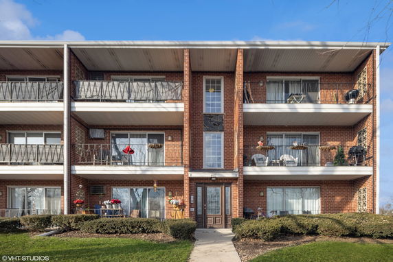 Front view of a three-story apartment building with balconies.