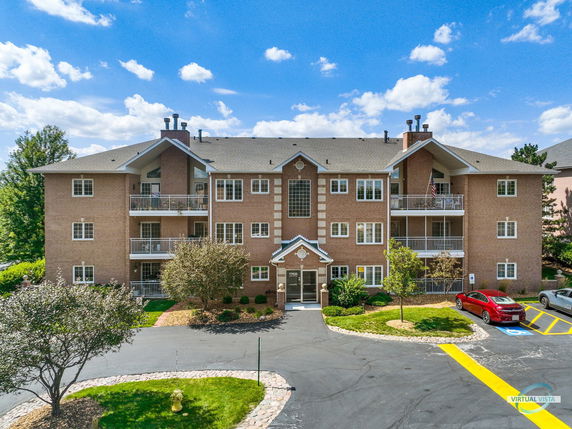 Front view of a multi-story brick apartment building with balconies.