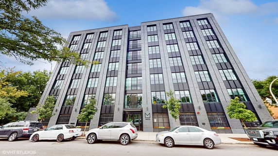 Front view of a multi-story building with large windows and a modern design.
