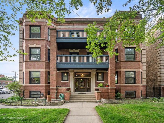 Front view of a multi-story brick building with balconies.