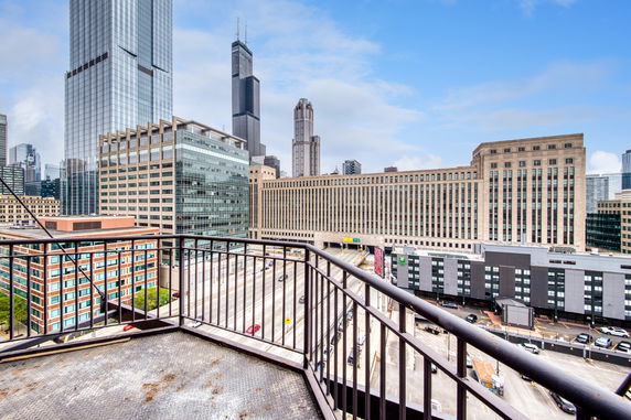 View from a building balcony overlooking a cityscape with multiple skyscrapers and roads.