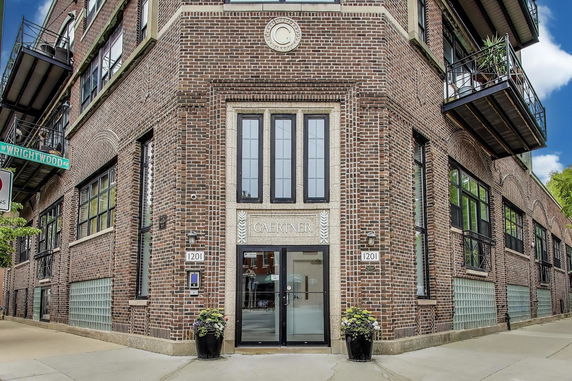 Front view of a multi-story brick building with large windows and balconies.