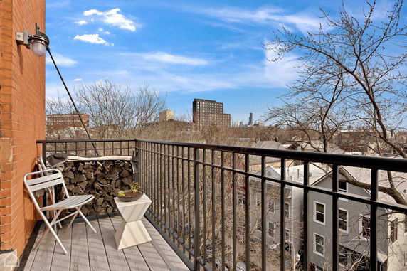 View from a balcony showing cityscape and buildings in the distance.