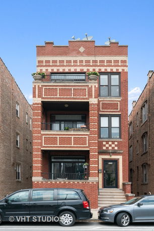 Front view of a multi-story brick building with balconies.