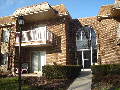 Front view of a multi-story brick building with balconies and large arched windows.