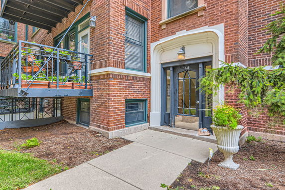 Front view of a brick building entrance with a small balcony.