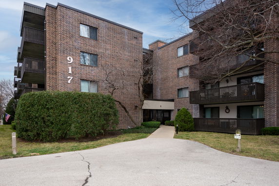 Front view of a multi-story apartment building with balconies.