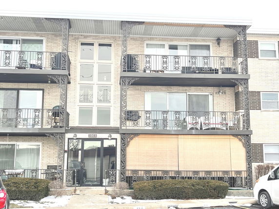 Front view of a multi-story residential building with balconies.