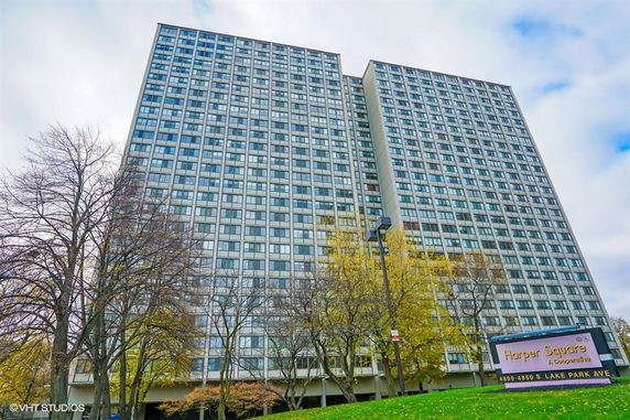 Front view of a multi-story residential building with large windows.