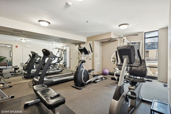 Interior view of a gym with exercise equipment including treadmills and elliptical machines.