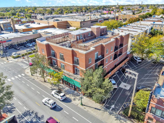 Front view of a multi-story brick building on a street corner.