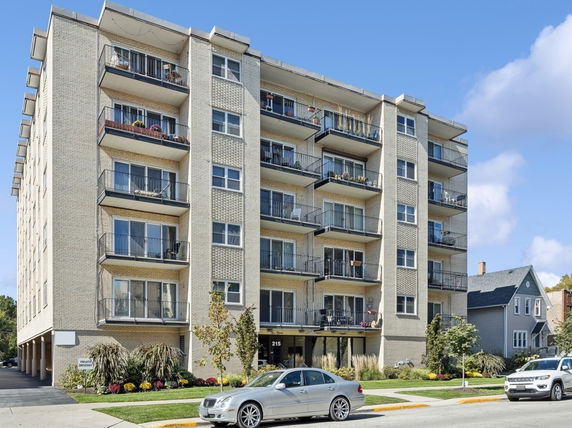 Front view of a multi-story apartment building with balconies.