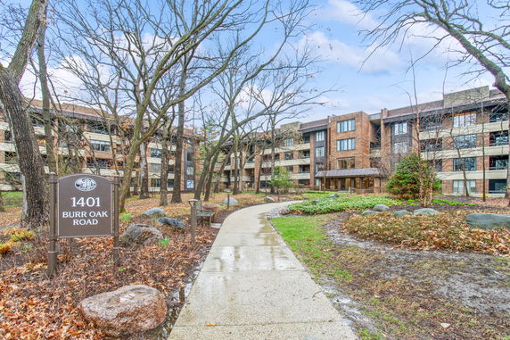 Front view of a multi-story residential building with a pathway leading to the entrance.