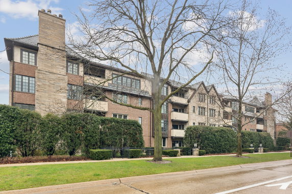 Front view of a multi-story residential building with a stone and brick facade.