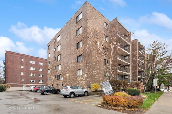 View of a multi-story brick apartment building with balconies.