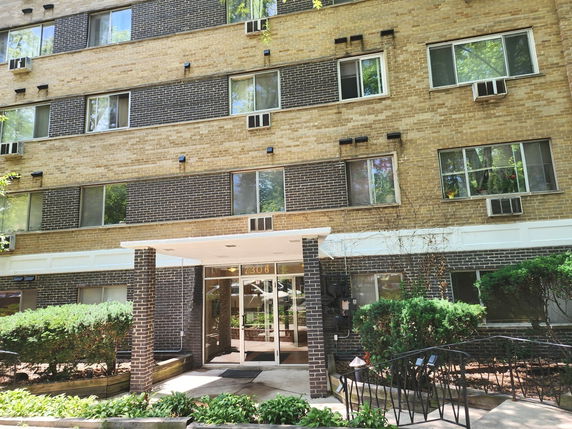 Front view of a multi-story residential building with a prominent entrance.