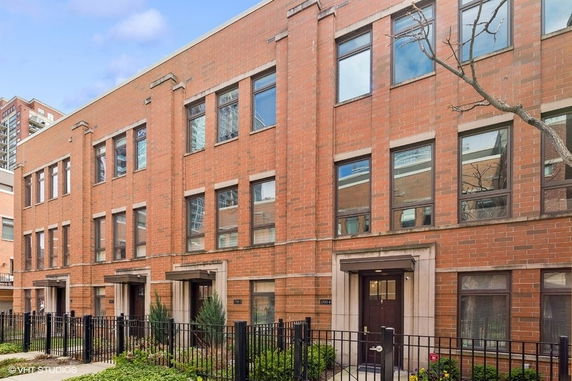 Front view of a multi-story brick building with multiple entrances.