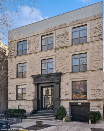 Front view of a multi-story building with large windows and a garage entrance.