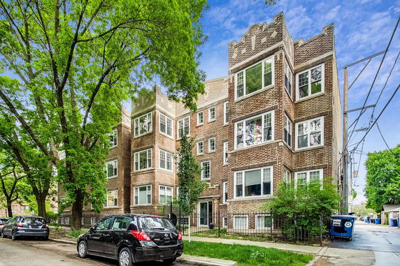 Front view of a brick multi-story apartment building.