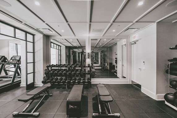 Interior view of a gym with exercise equipment and mirrors.