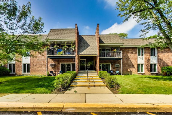 Front view of a two-story brick residential building with balconies and a central entrance.