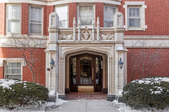 Front view of a brick building with an ornate stone entrance.