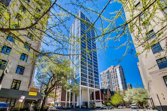 Front view of a modern high-rise building with a glass facade in an urban setting.
