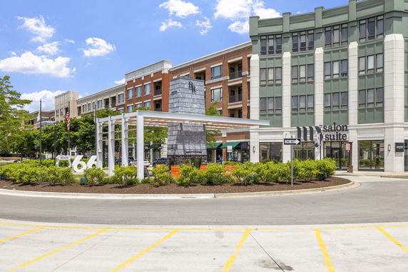 Front view of a commercial building with multiple stories and a sign for a salon suite.