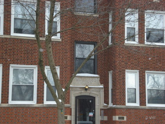Front view of a brick building with multiple windows and a central entrance.