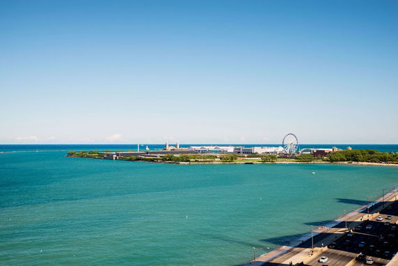Panoramic view of waterfront with a Ferris wheel and a long road along the shore.