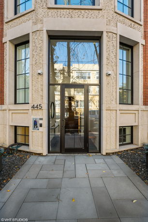 Front view of a modern multi-story building entrance with large windows and glass door.
