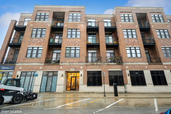 Front view of a multi-story brick building with balconies.