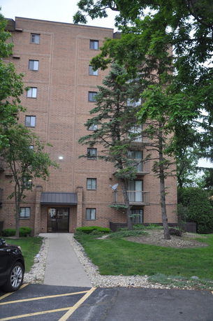 Front view of a multi-story brick apartment building.