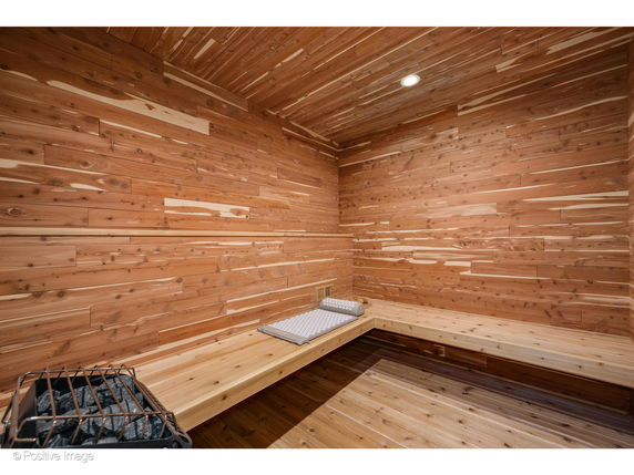 Interior of a wooden sauna room with benches and a heater.